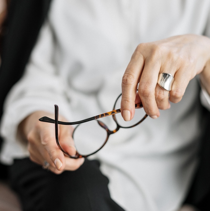 A North Port, FL therapist holds a pair of glasses, symbolizing clear vision and understanding in therapy.