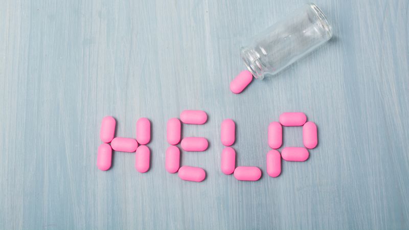 A photo of pills that says "help" signifying addiction trauma therapy in North